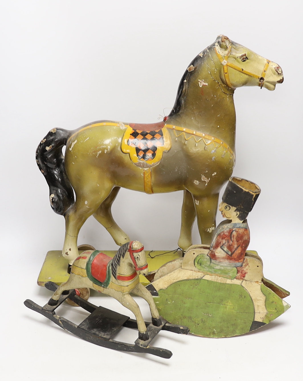A toy pull-along horse and two toy rocking horse models